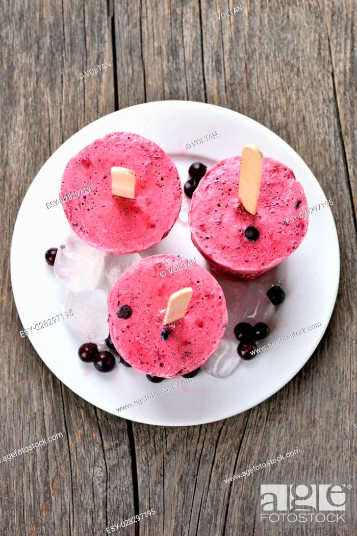 Stock Photo: Blueberry blackcurrant popsicles made in plastic cups on plate, top view.