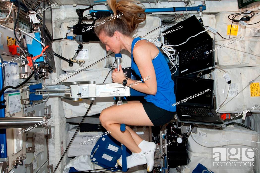 Stock Photo: NASA astronaut Karen Nyberg, Expedition 37 flight engineer, performs Body Mass Measurement activities using the Space Linear Acceleration Mass Measurement.