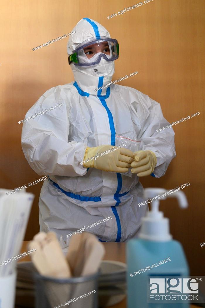 Stock Photo: 02 March 2021, Saxony, Radeberg: A health department employee prepares for a mass test for residents of the region in the gymnasium of the Radeberg vocational.