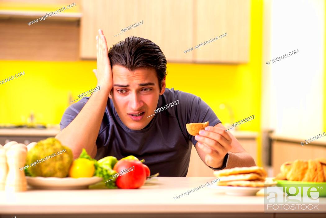 Stock Photo: Man having hard choice between healthy and unhealthy food.
