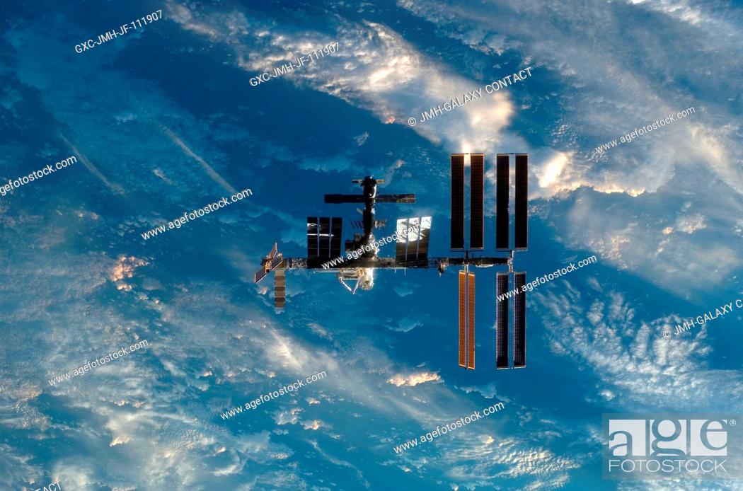 Stock Photo: Backdropped by a blue and white part of Earth, the International Space Station is seen from Space Shuttle Endeavour as the two spacecraft begin their relative.