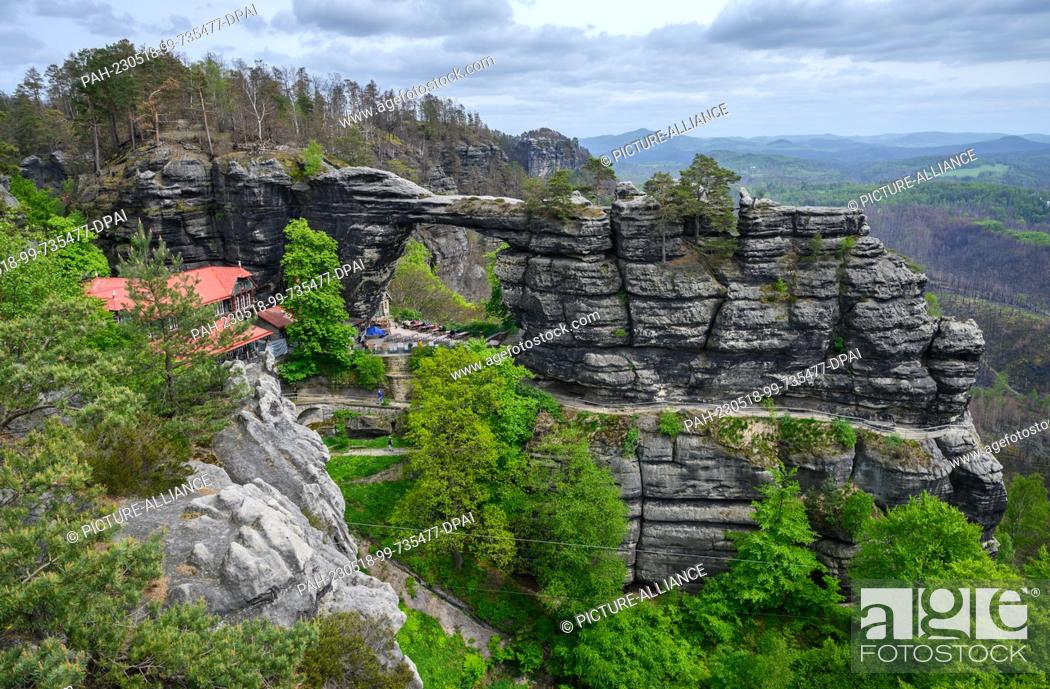 Stock Photo: PRODUCTION - 17 May 2023, Czech Republic, Hrensko: View of the rocks as well as the excursion restaurant at the Prebisch Gate.