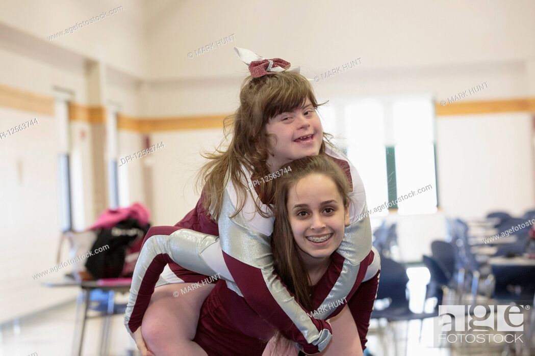 Stock Photo: Two cheerleaders having fun, one with Down Syndrome.