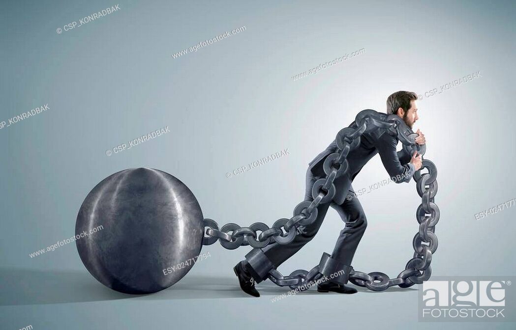Stock Photo: Tired businessman dragging heavy chains.