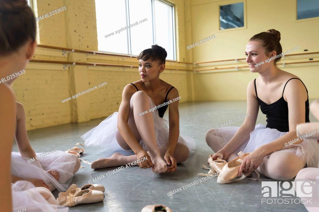 Stock Photo: Girls sitting on floor and talking in ballet studio.