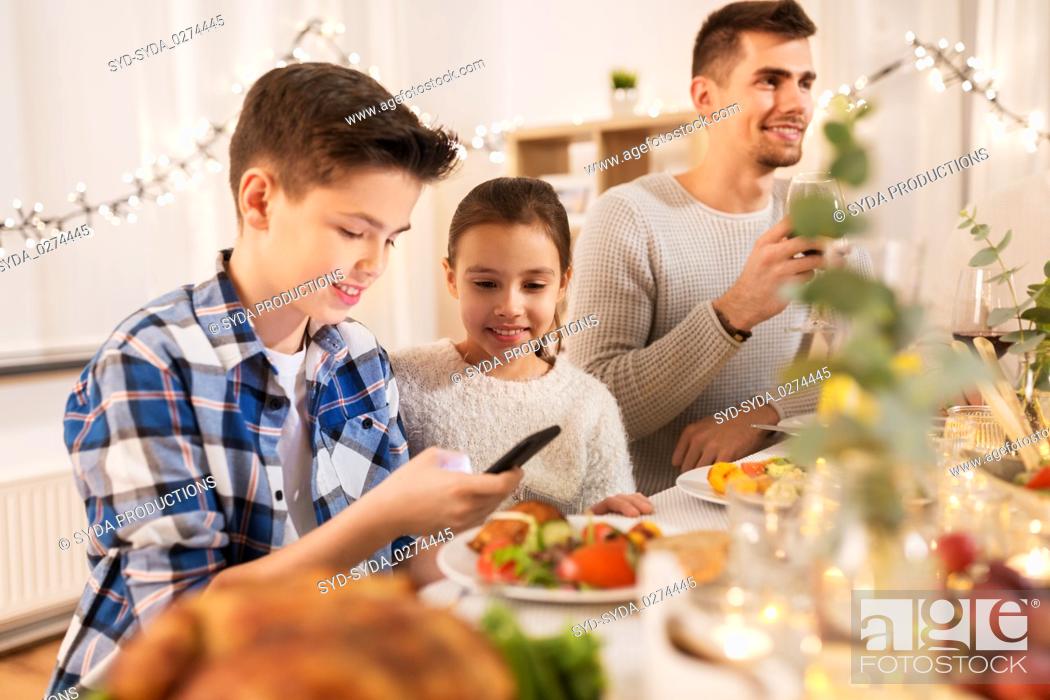 Stock Photo: children with smartphone at family dinner party.