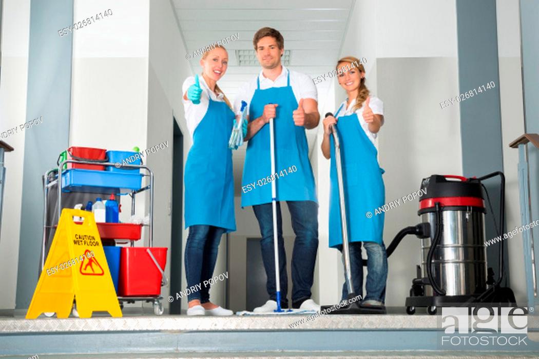 Stock Photo: Group Of Happy Young Janitor With Cleaning Equipment Showing Thumbs Up.