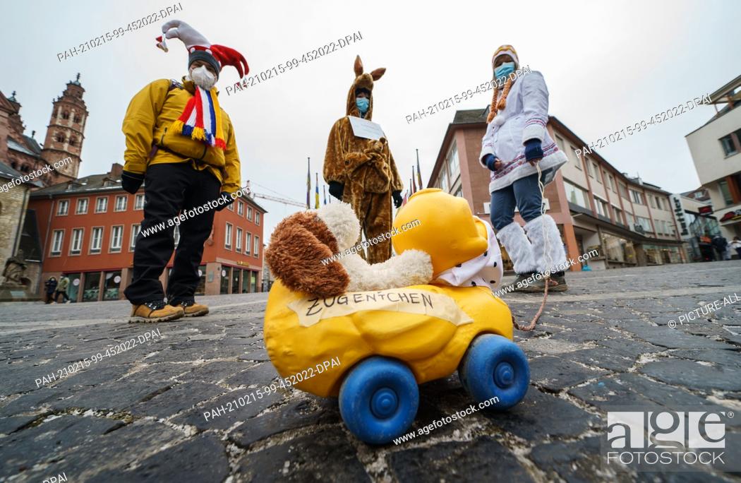 Stock Photo: 15 February 2021, Rhineland-Palatinate, Mainz: Markus (l-r), in a jester costume, Antonia, in a kangaroo costume, and Eva dressed as an Inuit.