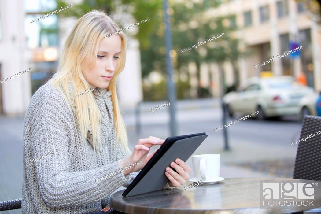 Stock Photo: Pretty young woman with tablet in a Cafe in city center.