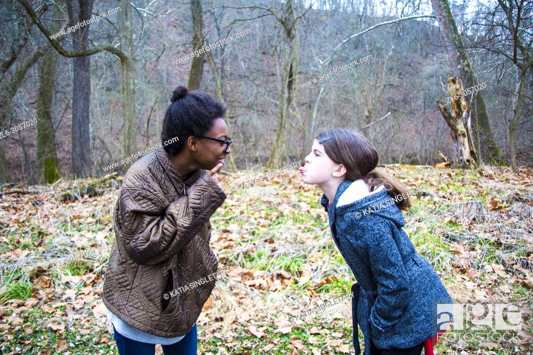 Stock Photo: Two teens/ Pre-teens arguing. One African American teen girl, yelling and correcting her caucasian friend/sister. She is bossing her around.