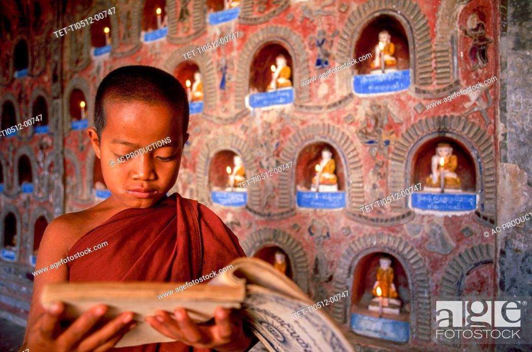Stock Photo: Myanmar, Shan State, Inle Lake, Novice Buddhist monk reading prayers in Shwe Yan Pyay Monastery.
