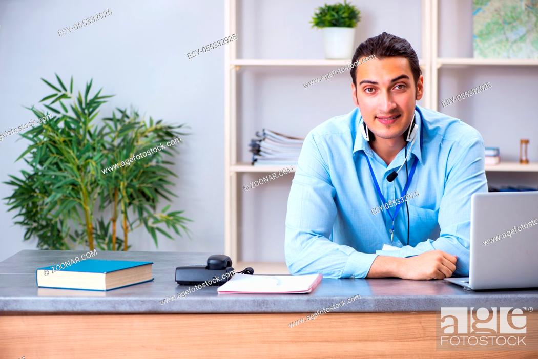 Photo de stock: The young male travel agent working in the office.