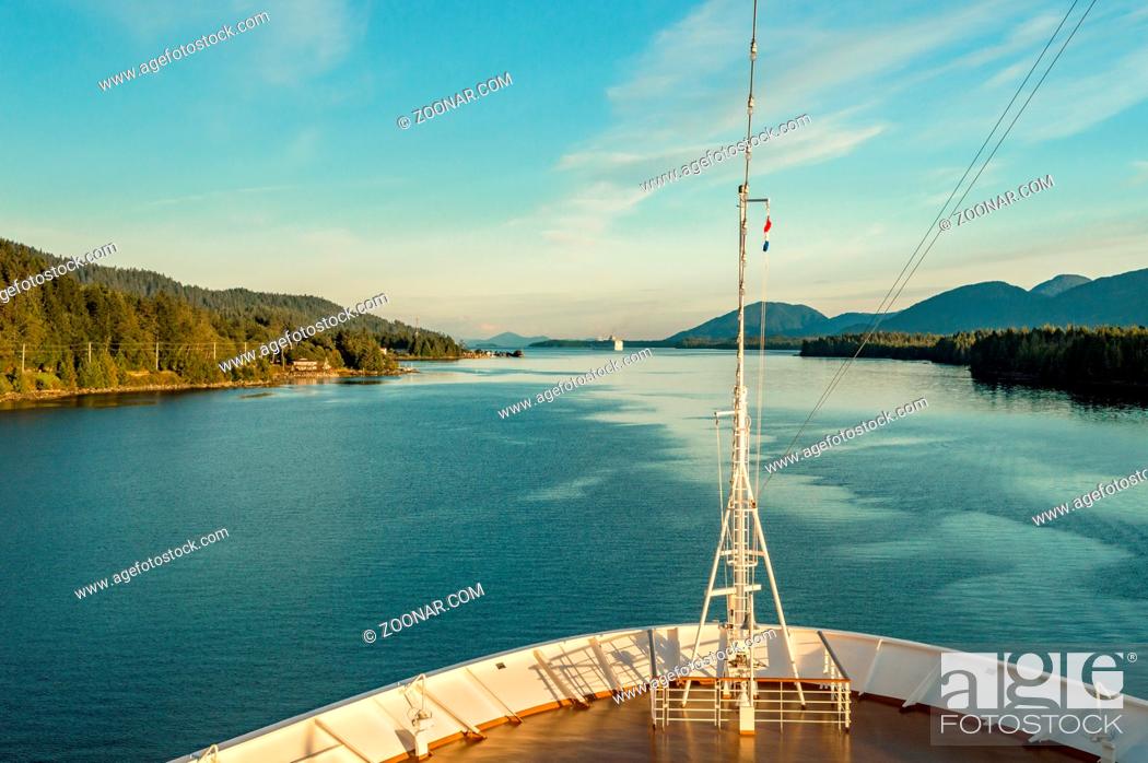 Imagen: Pointed white bow of cruise ship , southbound on ocean channel, Alaska Inside Passage, in warm afternoon sun, upper outside deck.