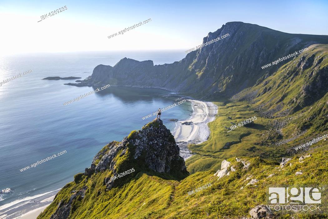 Stock Photo: Hiker standing at the precipice, cliffs, beach and sea, in the back peak of the mountain Måtinden, near Stave, Nordland, Norway, Europe.