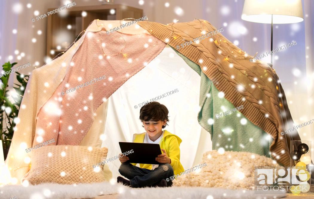 Stock Photo: little boy with tablet pc in kids tent at home.