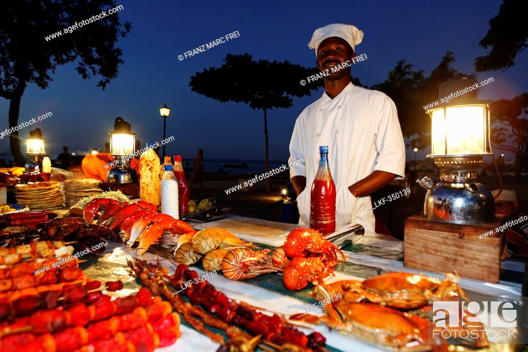 Photo de stock: Monger at a stand, night market at Forodhani Gardens, Stonetown, Zanzibar City, Zanzibar, Tanzania, Africa.