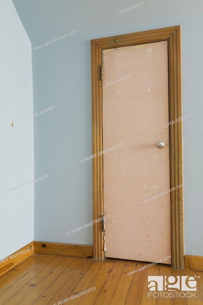 Stock Photo: Old wooden closet door covered with rose coloured wallpaper in blue bedroom on upstairs floor inside an old 1807 Canadiana style fieldstone home.