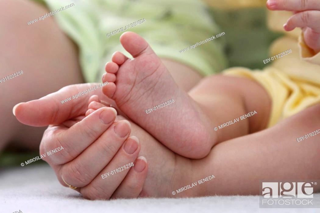 Stock Photo: Mother holding her childs feet.