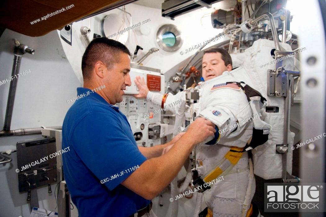 Stock Photo: Astronaut Nicholas Patrick, STS-130 mission specialist, participates in an Extravehicular Mobility Unit (EMU) spacesuit fit check in the Space Station Airlock.