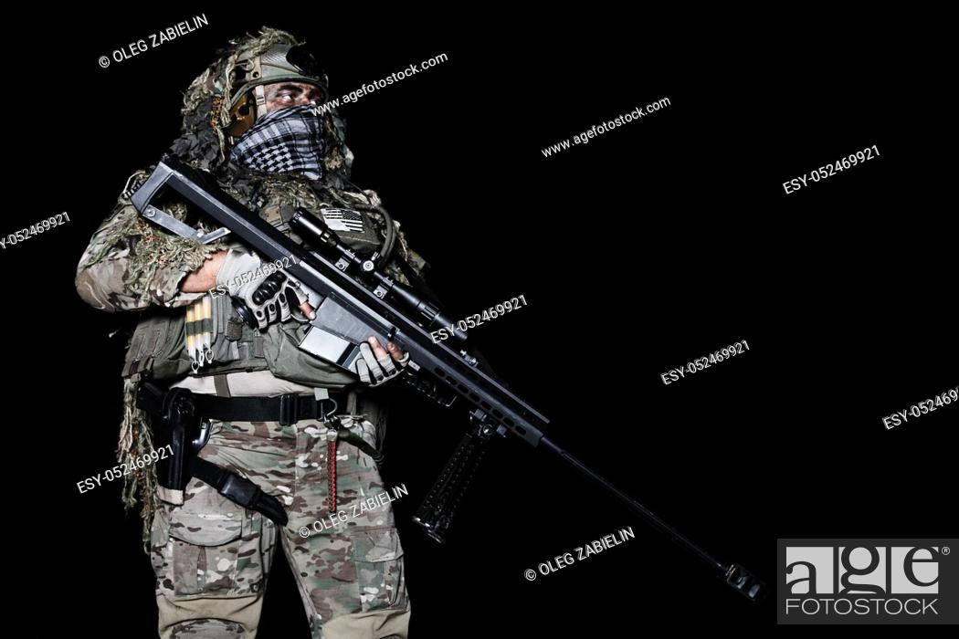 Imagen: Army sniper with big rifle standing on black background.