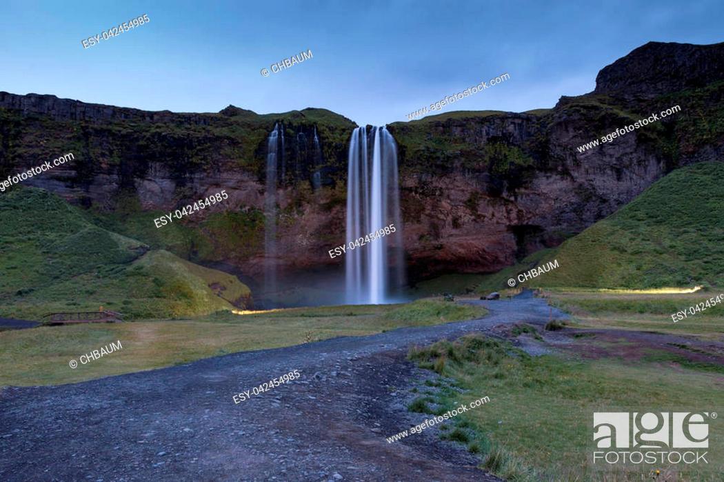 Imagen: Night shot of world famous Seljalandsfoss, a majestic waterfall in southern Iceland, coming down over a cliff, fed by a glacier.