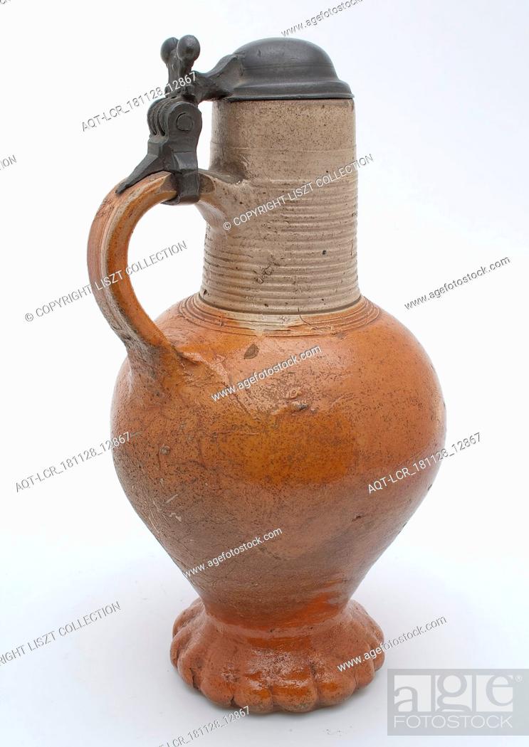 Stock Photo: Stoneware jug with handle, tin frame and lid, with ribbed neck and on squeeze foot, jug crockery holder soil find ceramic stoneware clay engobe glaze salt glaze.