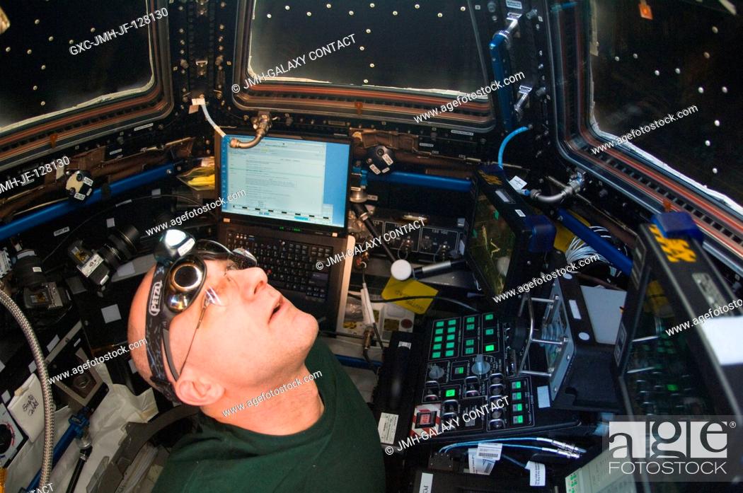 Stock Photo: NASA astronaut Don Pettit, Expedition 31 flight engineer, looks out one of Cupola windows on the International Space Station while the crew members were.