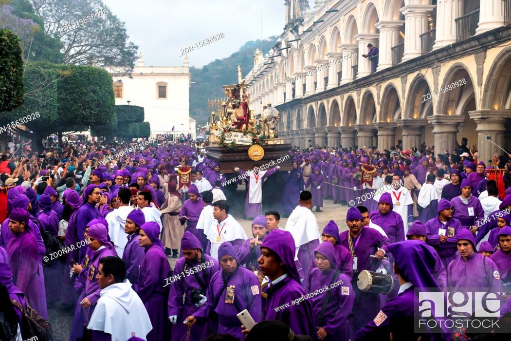 Stock Photo: Antigua, Guatemala: March 18 2018: Float with Christ statue carried by purple robed men at the procession San Bartolome de Becerra at the Plaza Mayor.