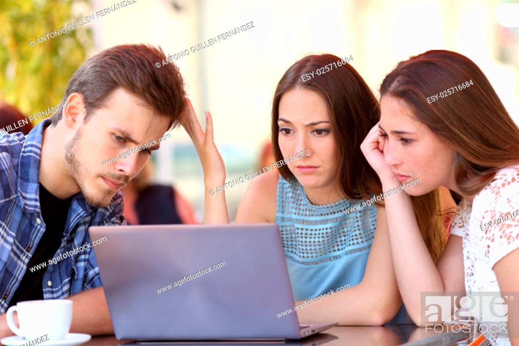 Stock Photo: Three upset friends online using a laptop with problems in a coffee shop.