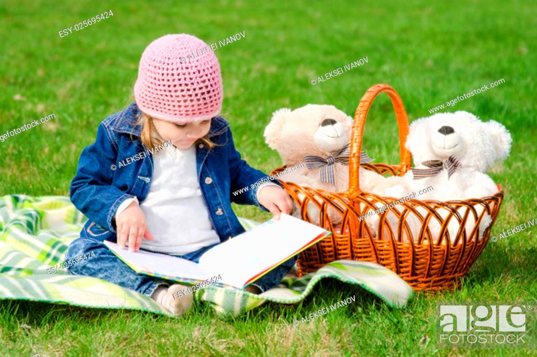 Imagen: The three-year girl is considering a book on picnic.