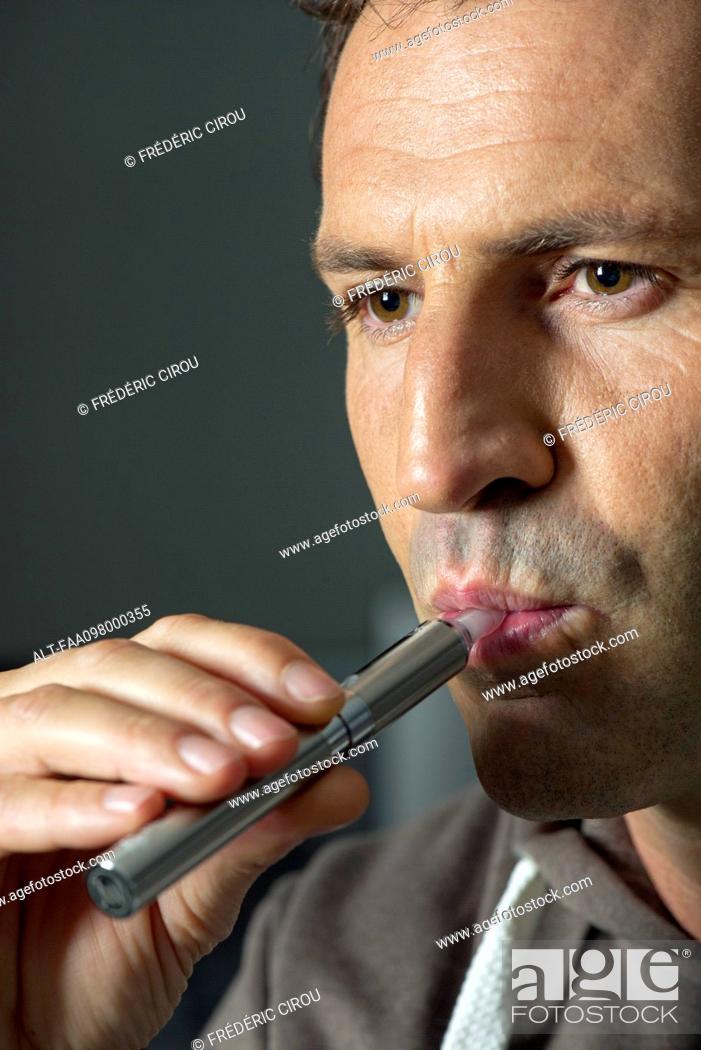 Stock Photo: Man smoking electonic cigarette.