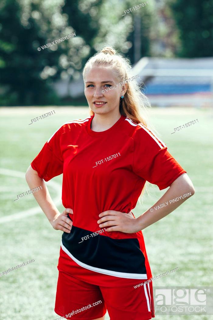 Stock Photo: Confident soccer player standing with hands on hip on field.