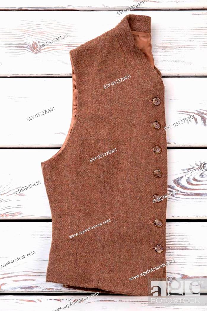Stock Photo: Retro sleeveless jacket. Folded brown woolen coat with buttons.