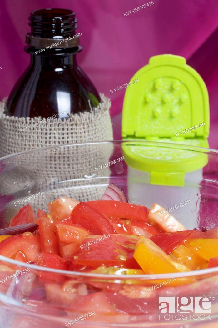 Stock Photo: Vegetables: tomatoes, onions are sliced for salad and placed in a glass container. Nearby is a bottle of vegetable oil and salt shaker.