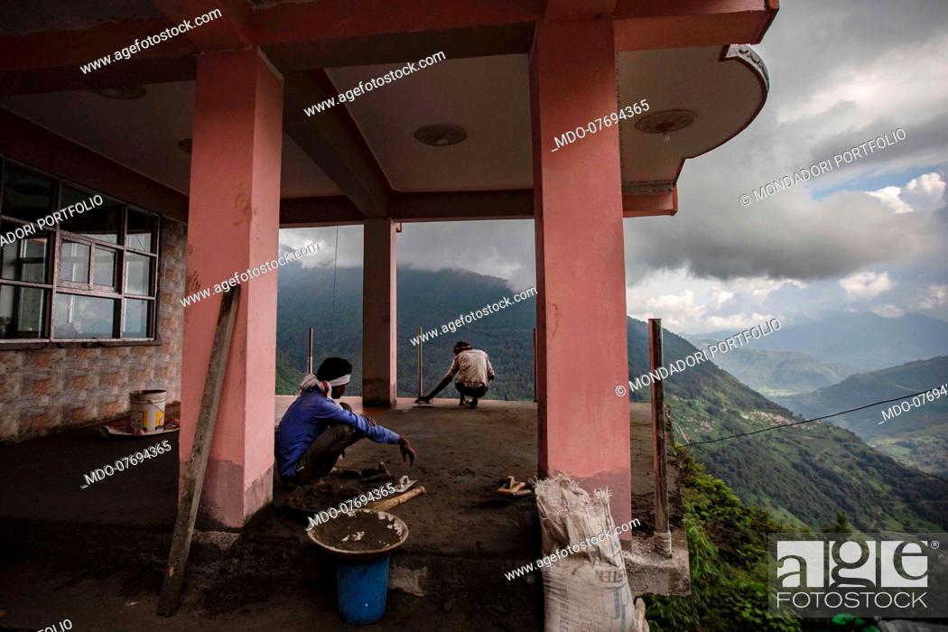 Stock Photo: Men at work to build a house. Annapurna Conservation Area (Nepal), August 21st 2019.