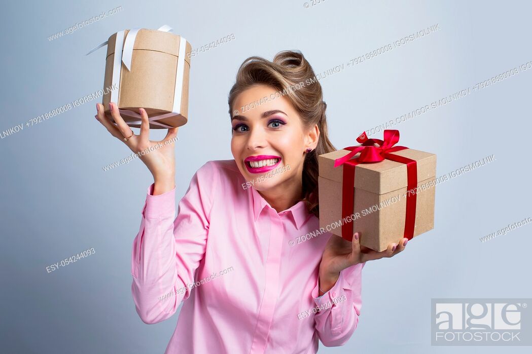 Imagen: Young happy woman holding two presents with bows.