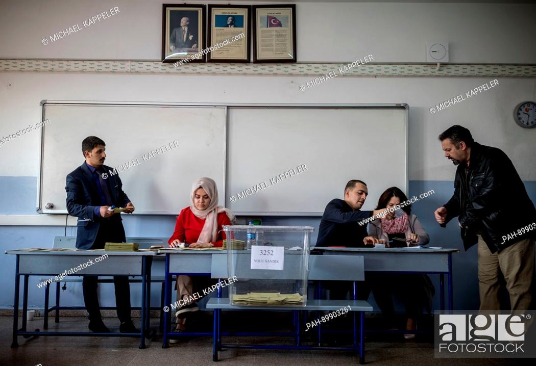 Stock Photo: Election assistants await for voters at a polling station in Istanbul, Turkey, 16 April 2017. Turkish citizens are voting on a constitutional amendment towards.