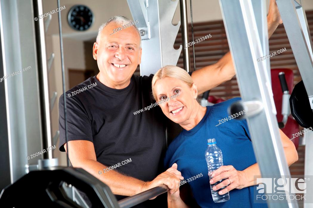 Stock Photo: Lachendes aktives Seniorenpaar trainiert im Fitnesscenter.