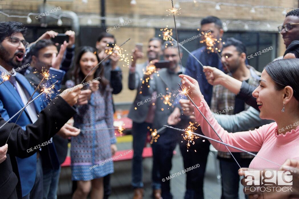 Stock Photo: Friends celebrating with sparklers at party.