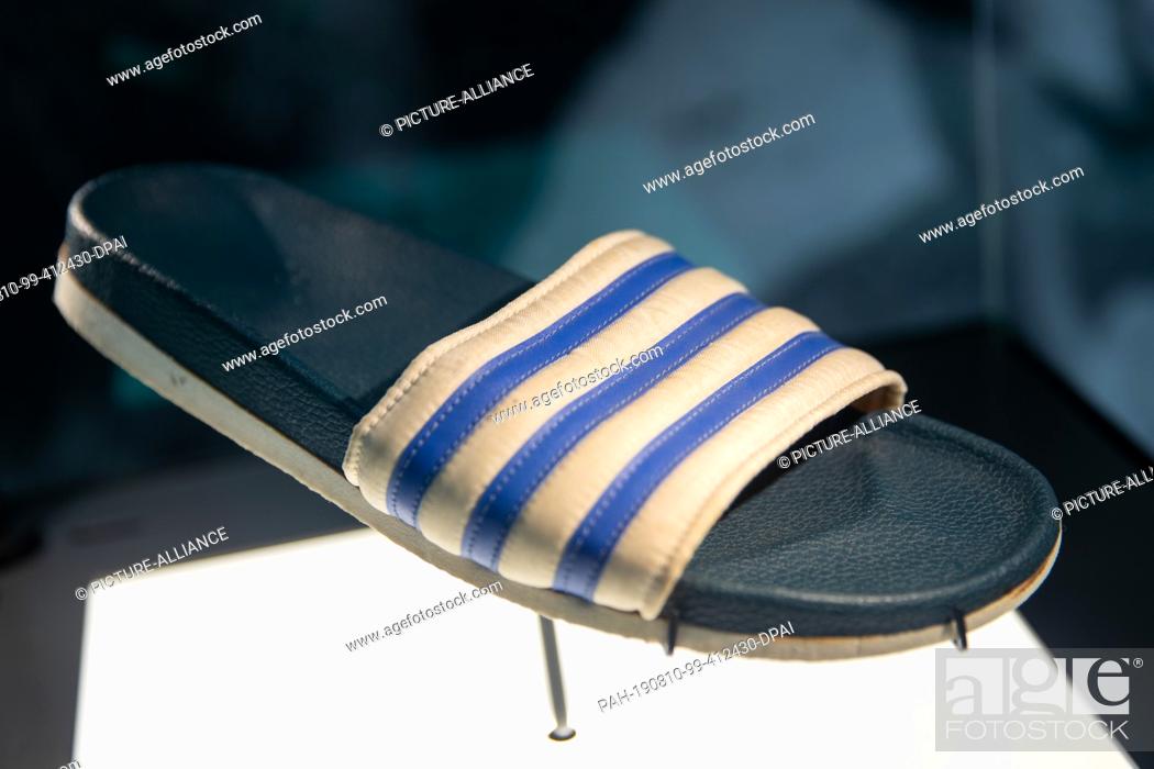 Domar polvo revisión 09 August 2019, Bavaria, Herzogenaurach: The shoe model ""Adilette"" from  1972 by the sporting goods..., Foto de Stock, Imagen Derechos Protegidos  Pic. PAH-190810-99-412430-DPAI | agefotostock