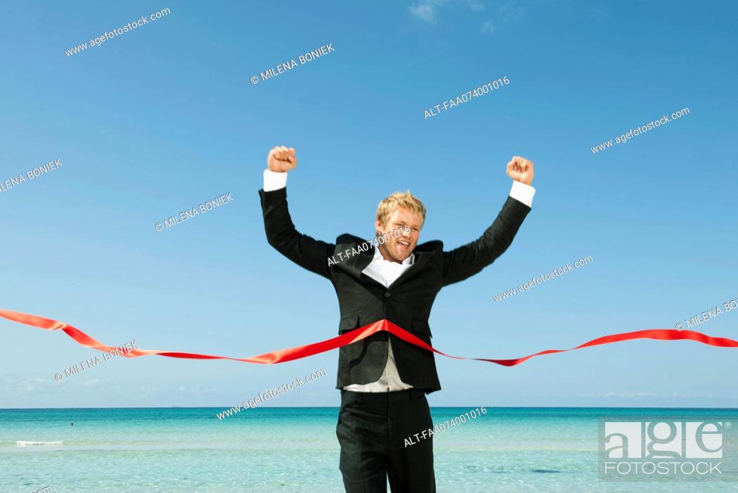 Imagen: Young businessman crossing finishing line.