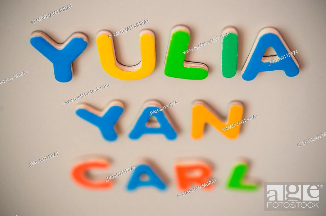 Stock Photo: ILLUSTRATION - The first names Yulia, Carl and Yan spelt out of magnet letters are sticking to a metal wall in Stuttgart, Germany, 15 July 2015.