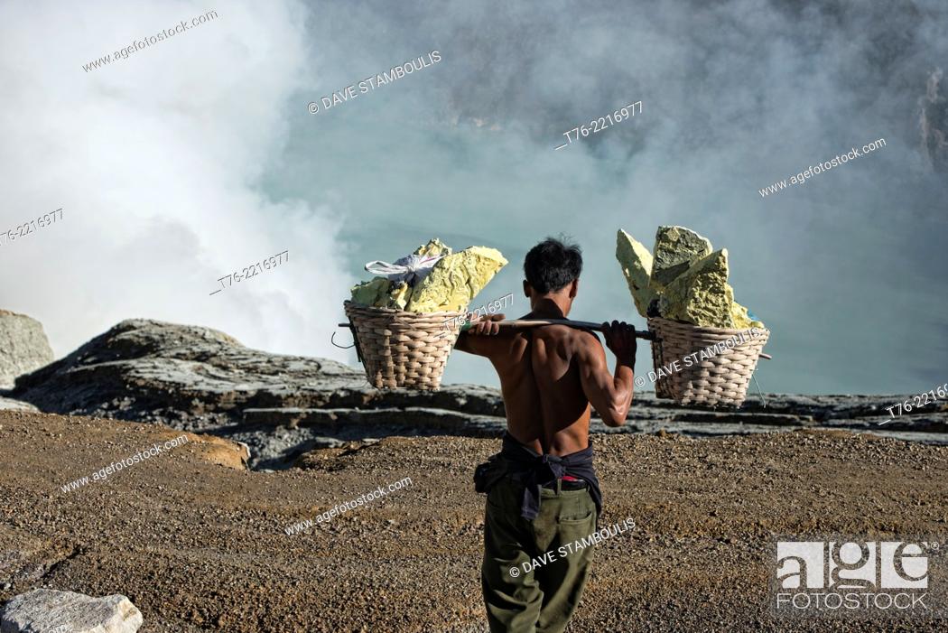 Stock Photo: Miner carrying a heavy load of sulphur at the Kawah Ijen volcanic crater, Java, Indonesia.