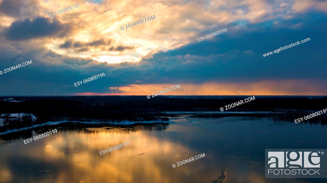 Stock Photo: Aerial view of a beautiful and dramatic sunset over a forest lake reflected in the water, landscape drone shot. Blakheide, Beerse, Belgium.