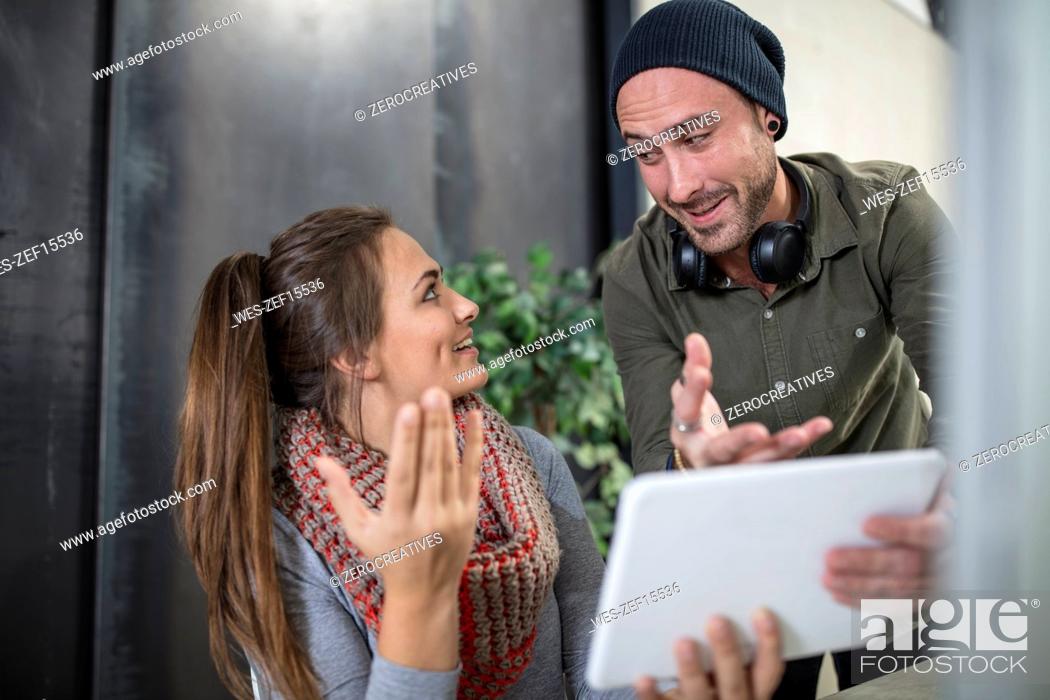 Stock Photo: Two colleagues with tablet talking in office.