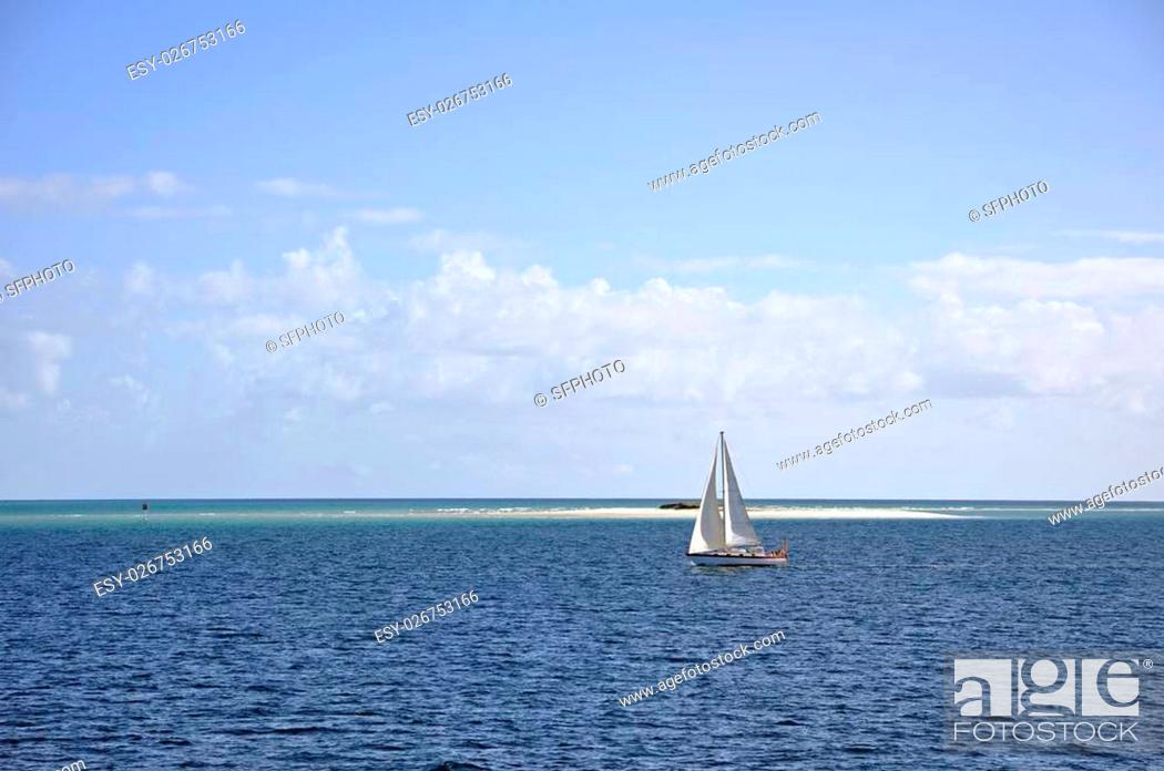 Stock Photo: unmarked sail boat with no visible crew cruising in the Great Sandy Straits at Moon Point Bank off the shores off Fraser Island, Queensland Australia.