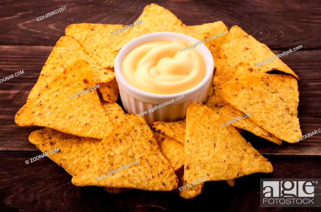 Stock Photo: Nachos and cheese dip on table.