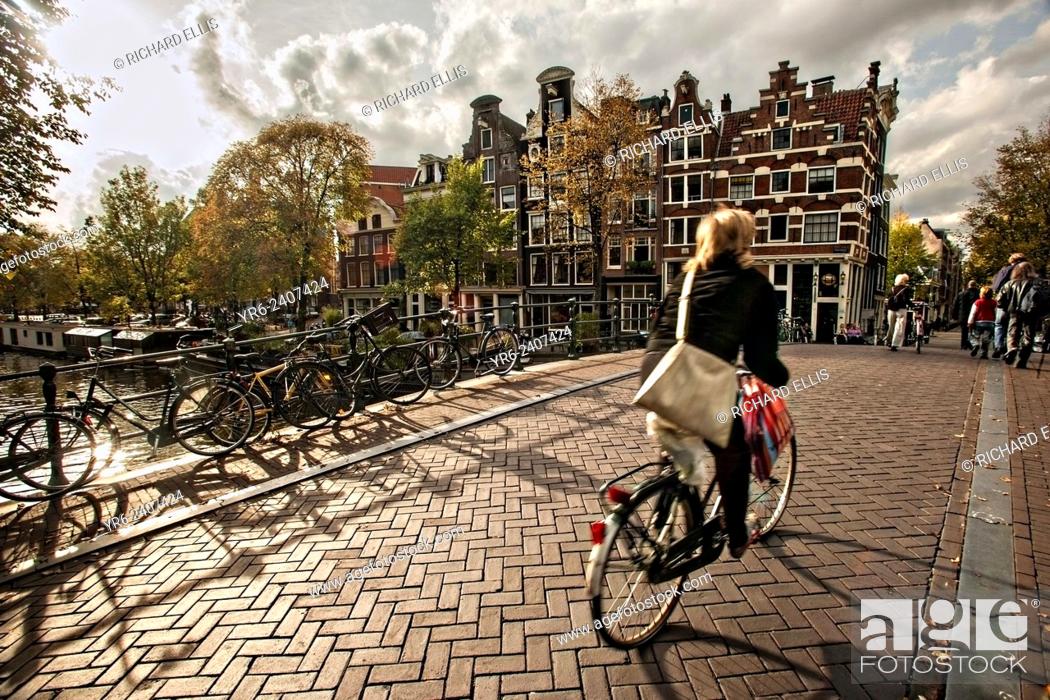 Stock Photo: Bicyclist crossing the the Hemonybrug bridge at Keizersgracht and Leidsegracht in Amsterdam.