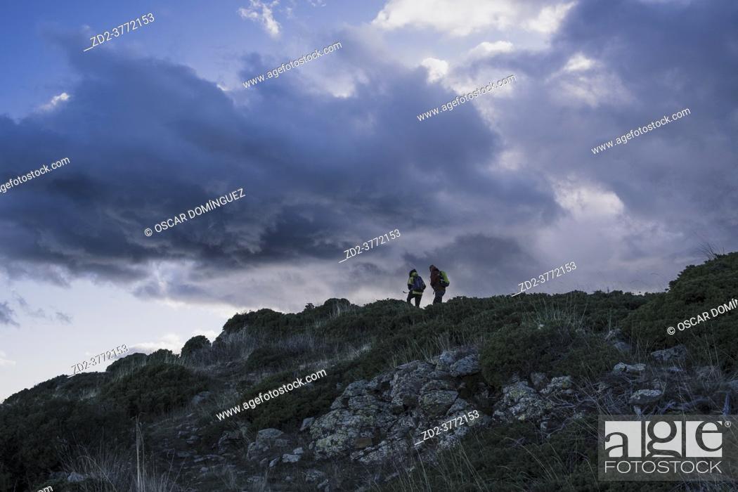 Stock Photo: Two mountaineers ascending the ridge between Les Agudes and Turó de l'Home. Montseny Natural Park. Catalonia. Spain.