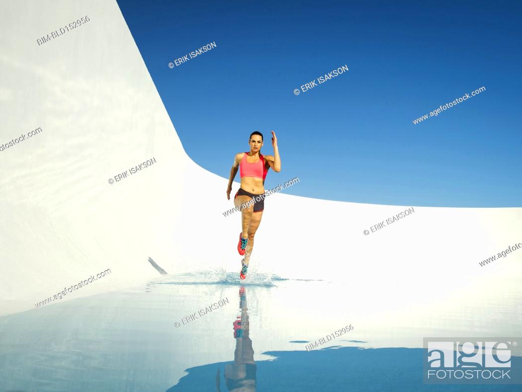 Stock Photo: Caucasian woman running on water surface.